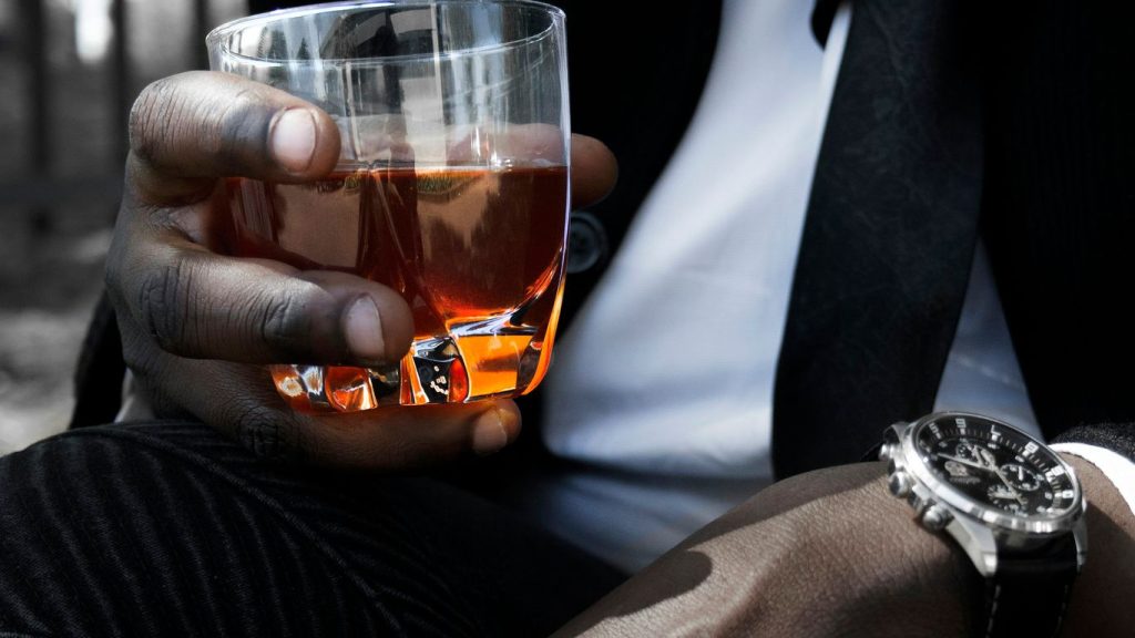 a person holding a glass of beer