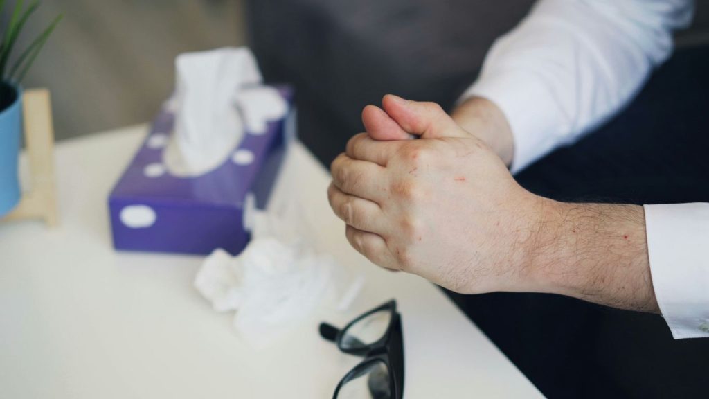 a man is holding his hand while sitting at a table