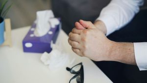 a man is holding his hand while sitting at a table