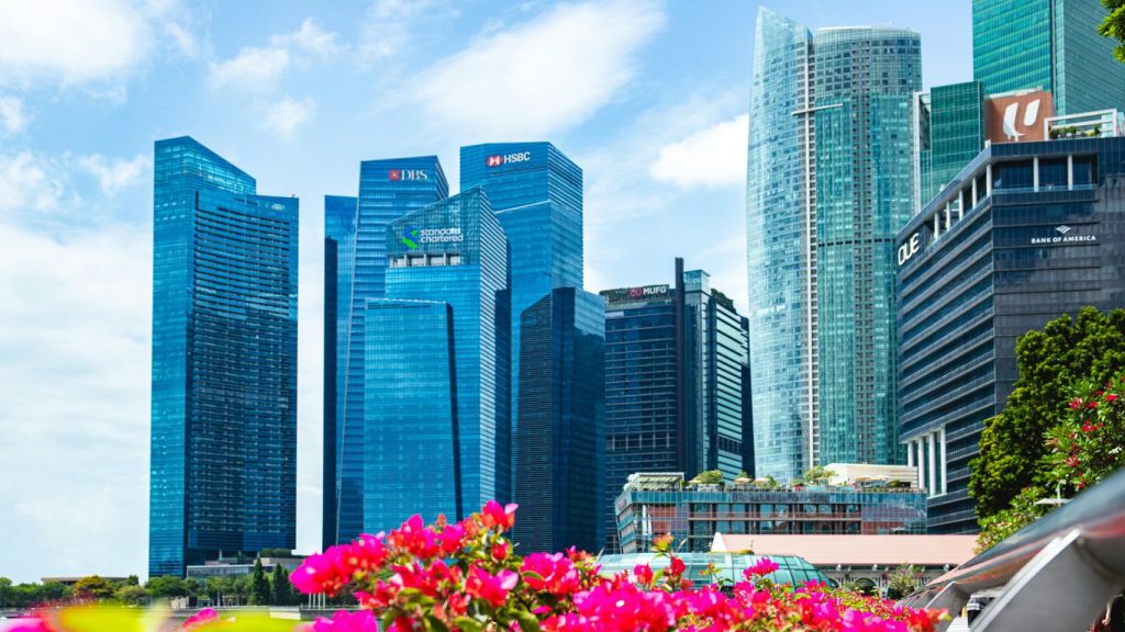 Modern skyscrapers rise above vibrant flowers
