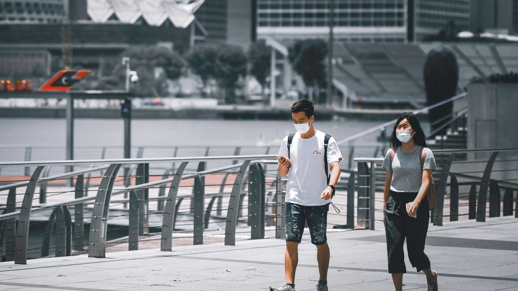 man in white crew neck t-shirt and black shorts standing beside woman in black tank