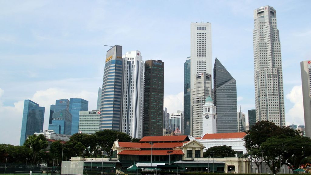 white and gray concrete building near green grass field under white sky during daytime