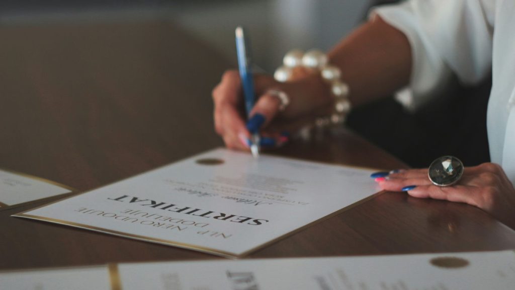 a woman writing on a piece of paper