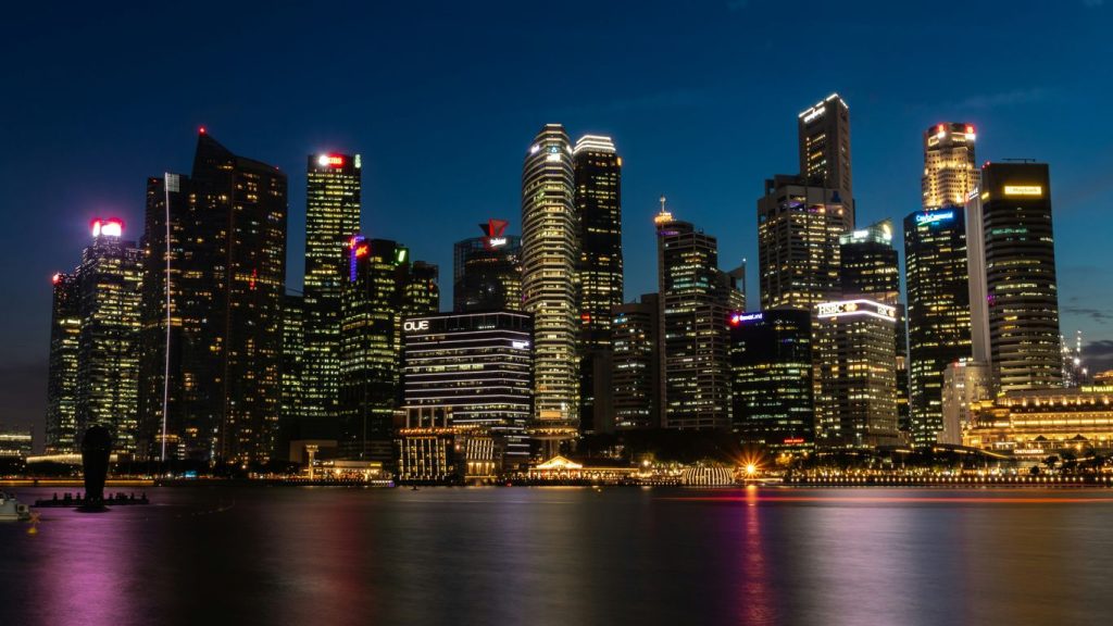 cityscape near the body of water with lights turned-on during nighttime