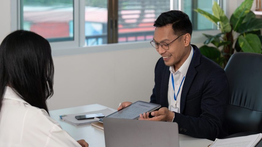 insurance consultation. professional discussing policy details with client in modern office.