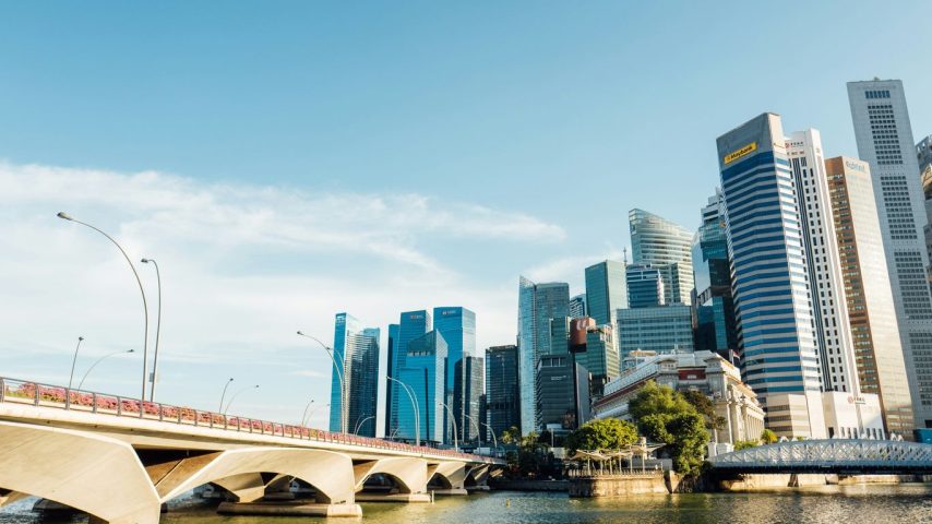 a bridge over a body of water with a city in the background