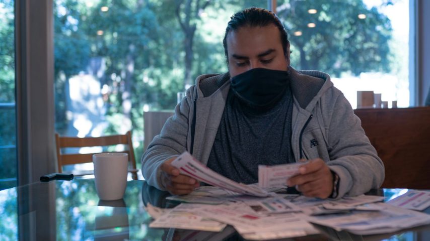 man in gray jacket reading newspaper