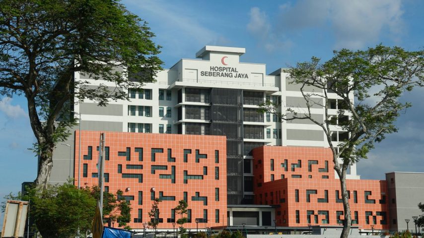 Modern hospital building with red crescent logo.