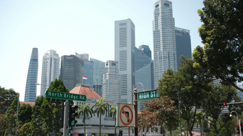 Modern skyscrapers in a bustling city with trees.