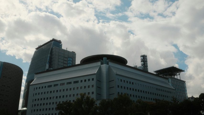 Modern building with helipad against cloudy sky