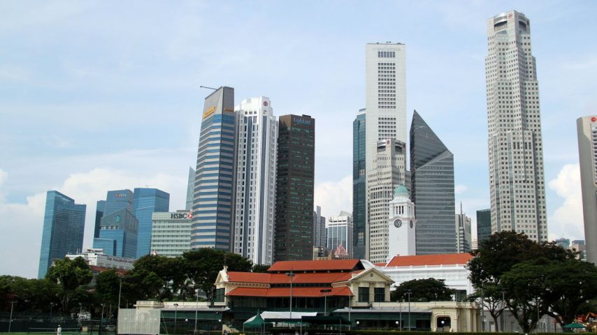 white and gray concrete building near green grass field under white sky during daytime
